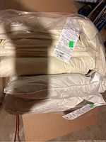 Duvet folded in plastic packaging, cream cotton fabric visible.