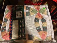Full view of queen size double wedding ring quilt in original packaging showing front pattern and brand label
