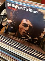Vinyl records visible in a rack, featuring Bob Marley and The Wailers 'Catch a Fire' album cover prominently
