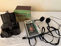 Photo showing the View-Master stereoscope, original box, and Sony Walkman with headphones laid on a table.