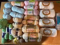 Top view of assorted yarn skeins and balls in multiple colors and brands