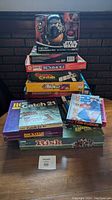 Stack of board games and Star Wars Frylo Ren Mr. Potato Head toy on top of the stack.