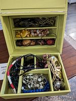 Jewelry box containing various beaded necklaces in multiple compartments, showing a range of bead shapes, colors, and materials.