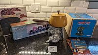 Photo of all items including aluminum fondue set with box, springform pan, jewel-tone candle tray with box, fondue fork, and instruction pamphlets on kitchen counter