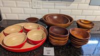 Photo of full lot on kitchen counter showing all bowls, bamboo set in front left, Baribocraft large wooden bowls back right, smaller stacked wooden bowls center right, and other various wooden bowls in front right