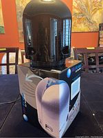 Black Airfree air sterilizer unit placed on top of the original product box in a room with red walls and paintings