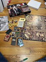 Full set of Clue Harry Potter Edition board game components including box, game board, cards, tokens, and instructions.