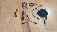 Photo showing all 9 stereo cables of various lengths and connectors laid out on wooden floor.