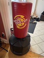 Front view of the Original Wave Master freestanding punching bag with red padded striking surface and black base filled and ready for use.