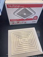 Packed box labeled NuTone Basic Ventilation Fan 696NC alongside the white plastic grille cover.