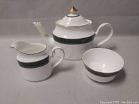 Full view of the tea set including teapot with lid, sugar bowl and creamer, showing design details and condition.