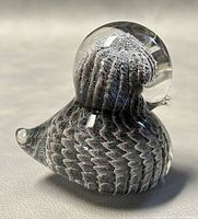 Left-front view showing bird profile and internal feather-like bubble pattern.