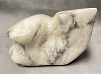 Front and side view of the abstract stone sculpture showing natural veining and polished surface.