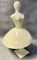 Front and side view of vintage metal female sculpture with white paint showing chips and wear.