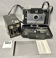 Polaroid Land Camera Automatic 100 and Kodak Target Brownie Six-20 cameras together with Polaroid Cold-Clip 193 instruction booklet.