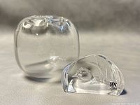 Clear glass Orrefors vase and Mats Jonasson signed glass duck paperweight shown from front angle on table