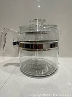 Front view image of the clear glass coffee pot showing the glass handle and stainless steel trim.