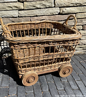 Full view of the rectangular bamboo basket with solid wooden wheels showing overall structure and condition.