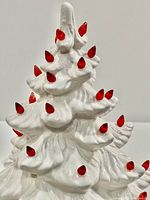 Close-up of the upper part of the white ceramic Christmas tree showing red bulb details.
