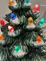 Close-up of mid and upper branches showing green glaze, white snow texture and colored bulbs