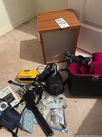 Full view of lot with light box, Pelican micro case, tripod, camera bag and accessory pouches on carpet floor.