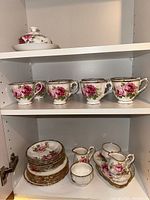 Shelf with 6 teacups, 6 saucers, 6 side plates, creamers, sugar bowl and butter dish