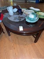 Photo of whole round wood coffee table with various ceramic and glass items on top (not included).