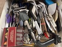 Wide view of assorted kitchen utensils and spatulas along with a boxed set of knives.
