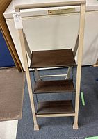 Front view of the folding step ladder showing frame and three wood-finished steps