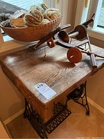 Wooden table top with vintage wooden spindles on top and sewing stand base below
