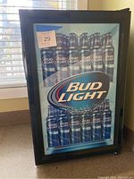 Frontal view of Bud Light branded beverage fridge showing graphic of Bud Light bottles and logo on glass door, with size and lot number sticker.