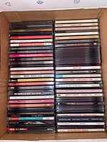 Photo displaying two stacks of CDs featuring female vocalists, showcasing titles from Mariah Carey, Barbra Streisand, Spice Girls, and more.