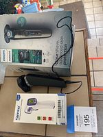 Philips Norelco shaver on box with Simzo digital thermometer box and charger cable visible, showing both items included.