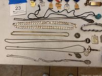 Various chain necklaces, bracelets and pendants laid out on tabletop