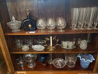 Shelves with various glassware including crystal bowls, decanter, snifter glasses and champagne flutes