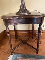 Front angle showing scalloped edges of the tabletop and turned legs.