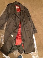 London Fog brown trench coat with visible orange lining, buttons, and lapel collar