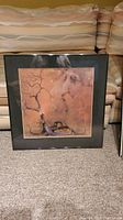 Framed art print with abstract design showing a tree and figure, signed Charles Bragg.