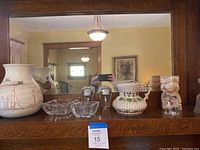 View of all items on mantle including large Redwing pottery vase, ceramic pitcher, stone owl, glass bowls and metal cups
