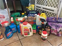 Photo of assorted lawn and garden bottles and products including Resolve, Windex, vegetable food, and charcoal.
