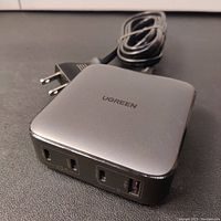 Photo showing the front and top side of the Ugreen charger with power cord and plug visible.