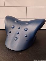 Front angled view of the blue foam neck and shoulder relaxer showing massage nodes on the surface