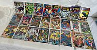 Photo showing about 30 DC Superman comic books, arranged in rows, displaying colorful covers with multiple Superman storylines and characters.