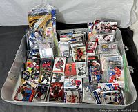 Wide view of the tray containing numerous hockey and baseball cards grouped in piles and plastic sleeves.
