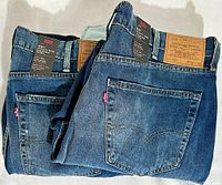 Two pairs of folded Levi's 541 Athletic Taper men's jeans in blue denim showing back pockets and leather brand patches with sizing W38 L30.