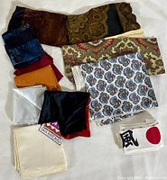 Top-down image showing the full assortment of pocket squares and linens with various colors and patterns, arranged on a white surface.