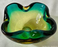 Top angled view of the glass ashtray showing the yellow to green color transition and wave-like rim shape.