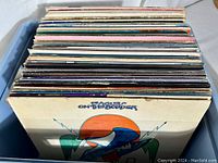 Box of vinyl LP albums viewed from top, showing various album covers and spines