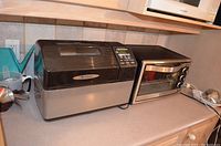 Zojirushi breadmaker next to Oster toaster oven on kitchen counter