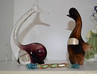 Whale, penguin, and candy Murano glass figurines shown together on shelf